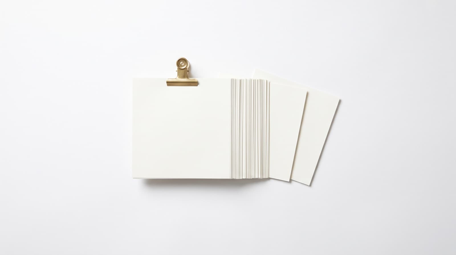 A thick clipped stack of blank estimate sheets with three sheets fanned out beside it