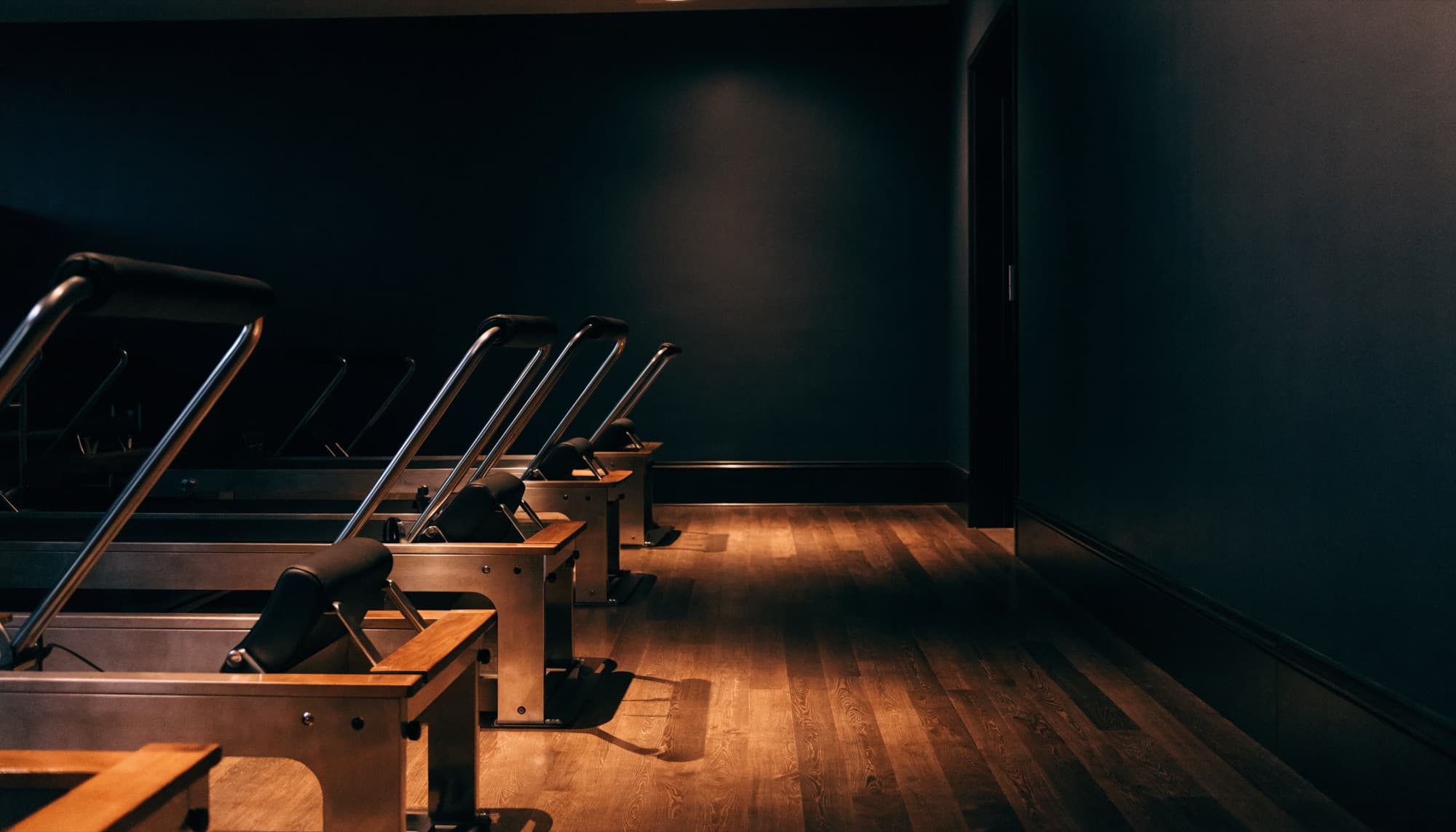 A boutique reformer pilates studio in low warm light
