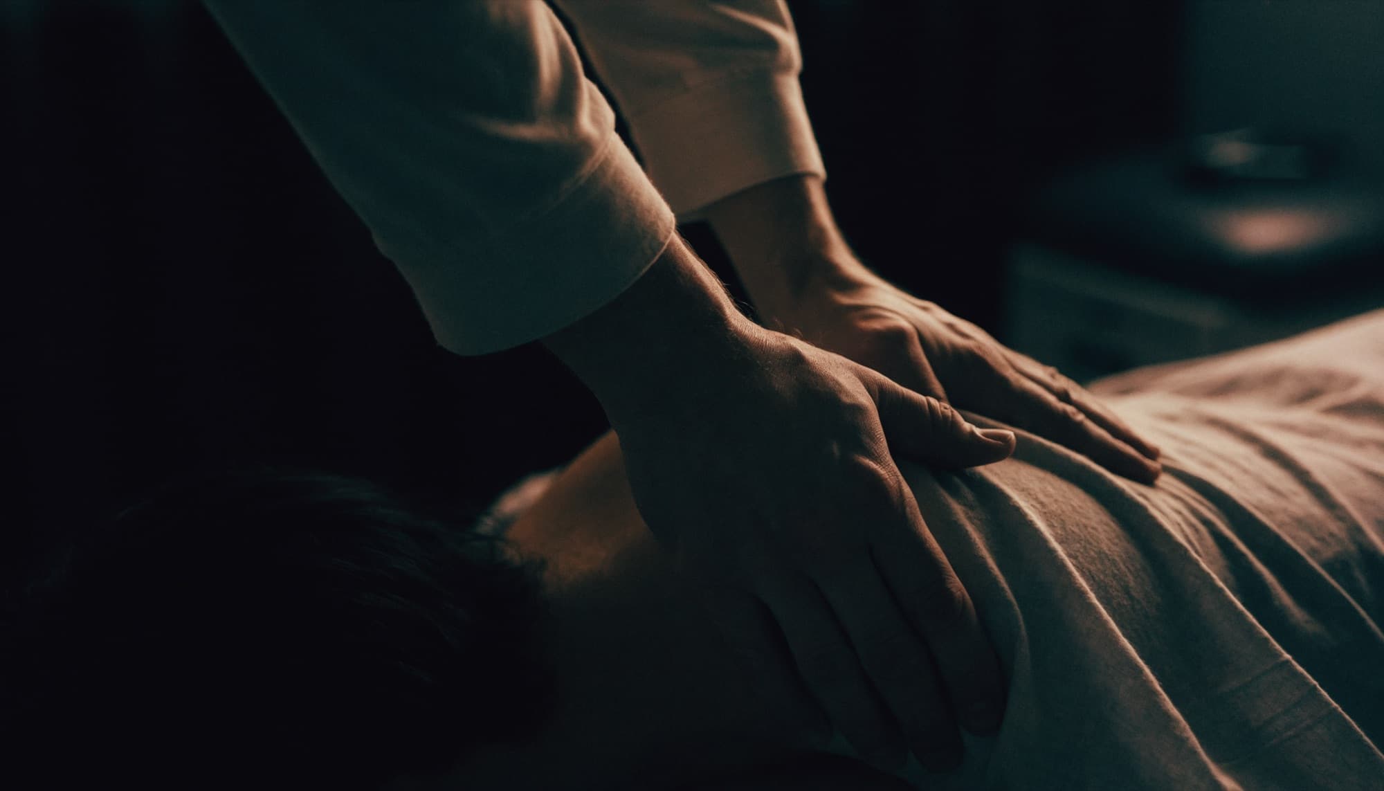 A chiropractor's hands positioned on a patient's back mid-adjustment