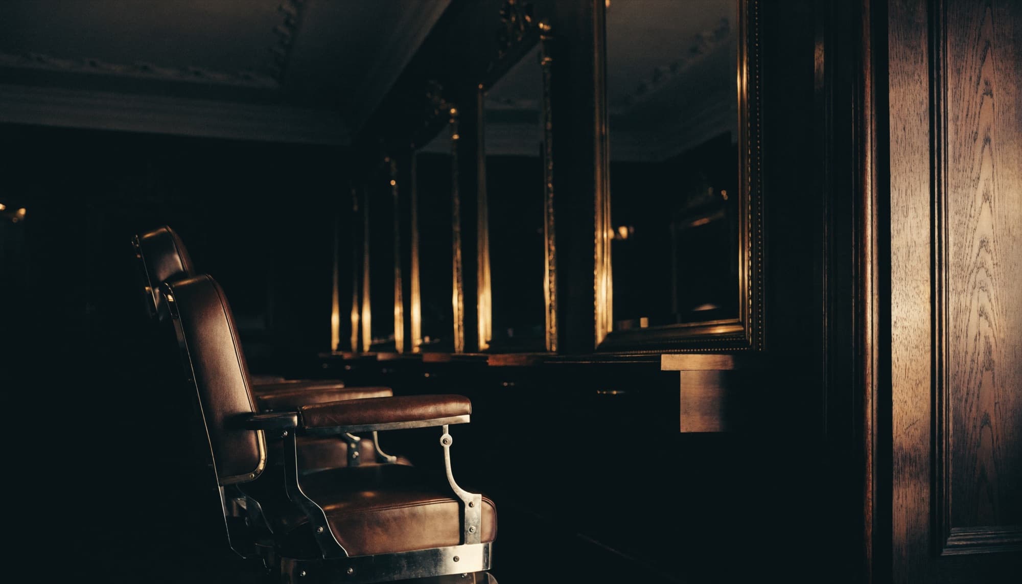 A high-end barbershop interior in low warm light