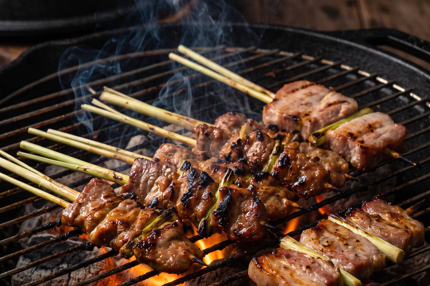 Lemongrass pork caramelising over charcoal embers